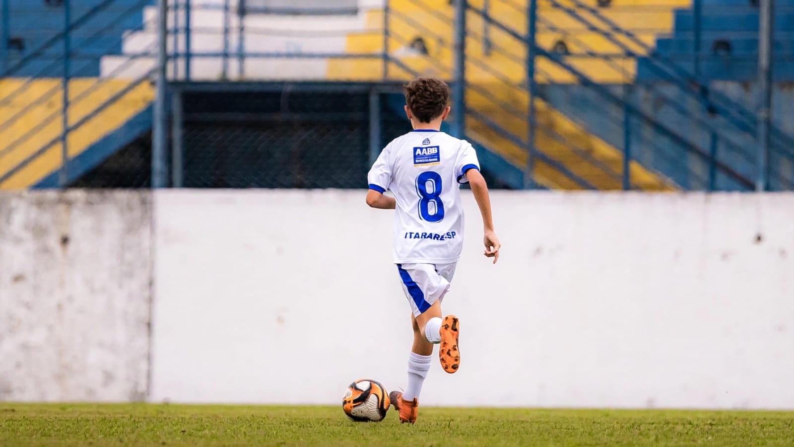 Theo Marques de costas, uniforme branco AABB Itararé-SP, camisa 8, conduzindo a bola